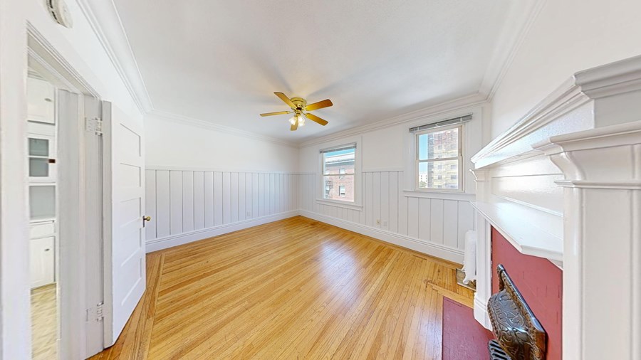 A room with wooden floors and a ceiling fan.